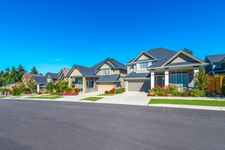 Some homes on the empty street in the suburbs.