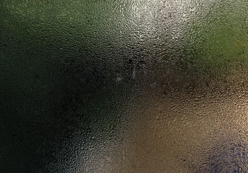 A window with condensation obscuring the view.