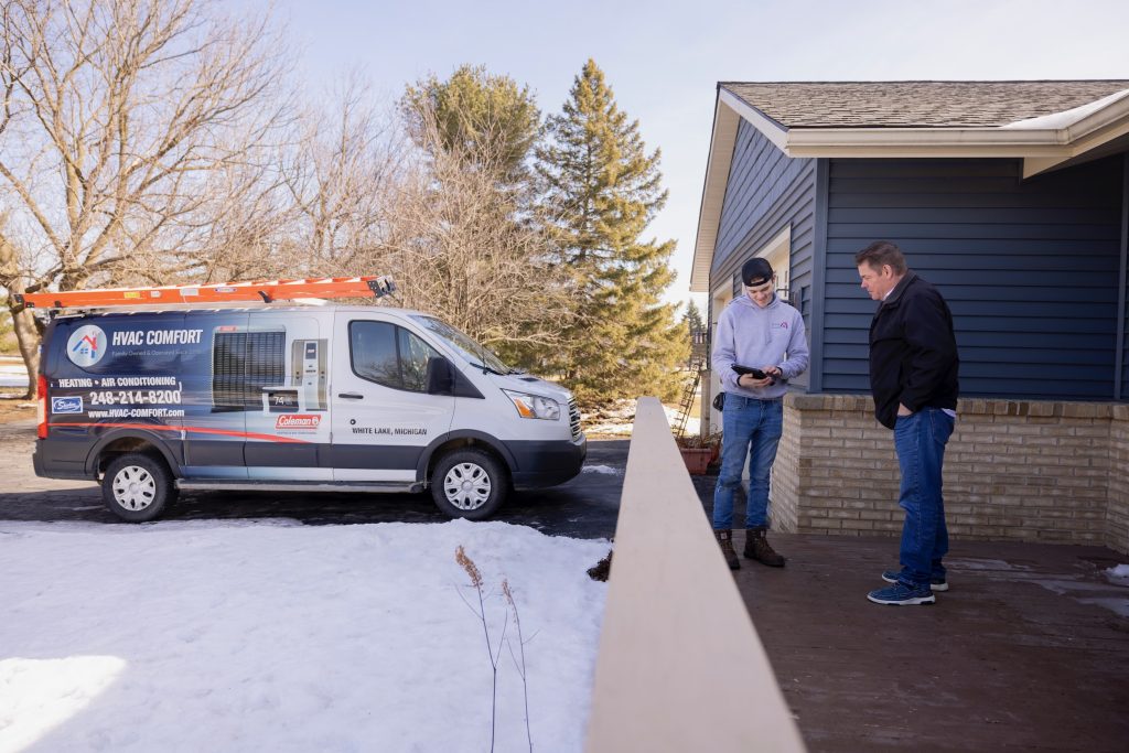hvac comfort inc hero photo heating and cooling professional in front of white lake home