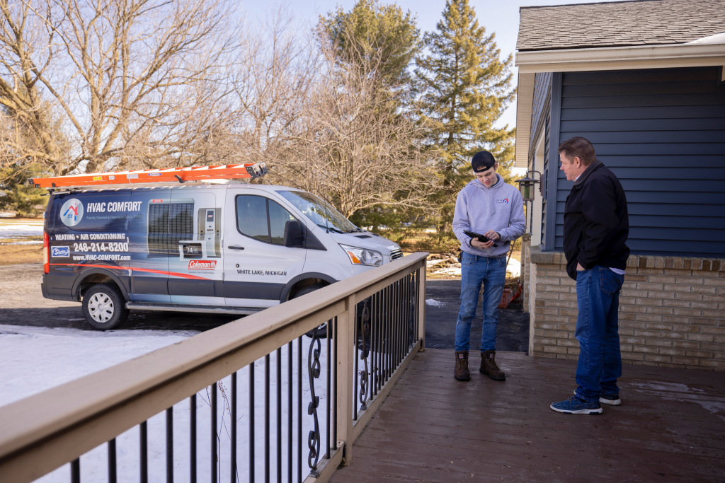 furnace and ac technician talking to customer outside of home about low cost hvac replacement near White Lake