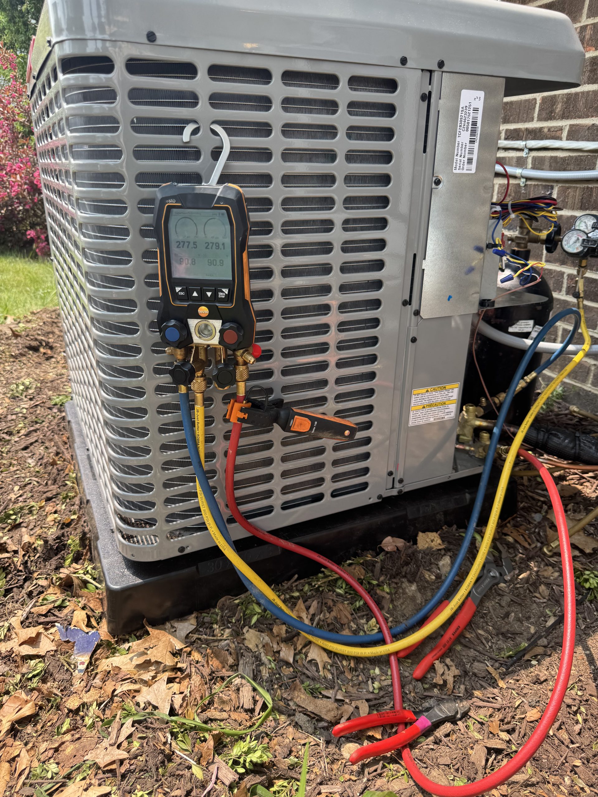 AC repair technician servicing air conditioning unit in Howell MI